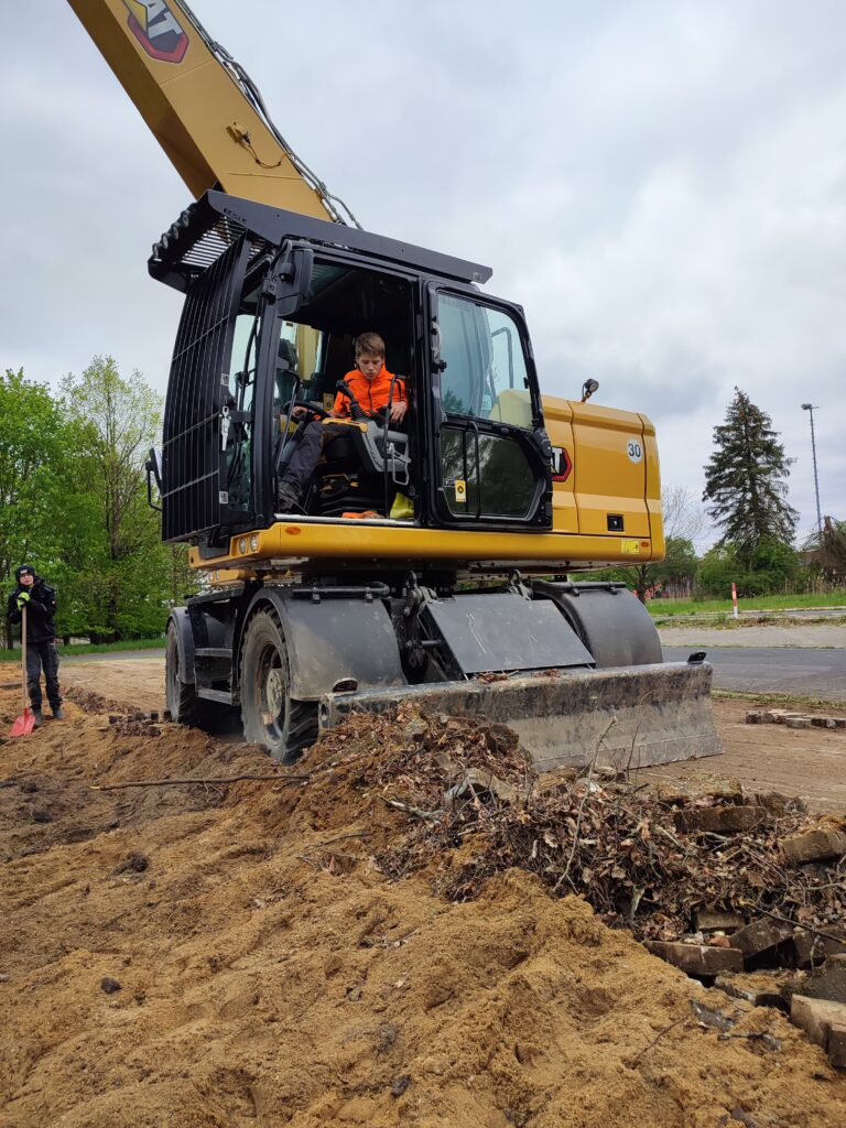 Die von den Pflastersteinen befreite Fläche wird mit dem Bagger geglättet. 