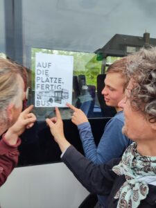 Auf die Plätze fertig Bus - das Motto für den rollstuhlgerechten Umbau von Bus "Bernhard" hängt als Plakat am Fenster. 