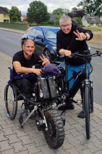 Momente von Veranstaltungen und Aktionen von Einsweiter. Majon mit E-Bike und ein Besucher mit Rollstuhl und E-Handbike. 