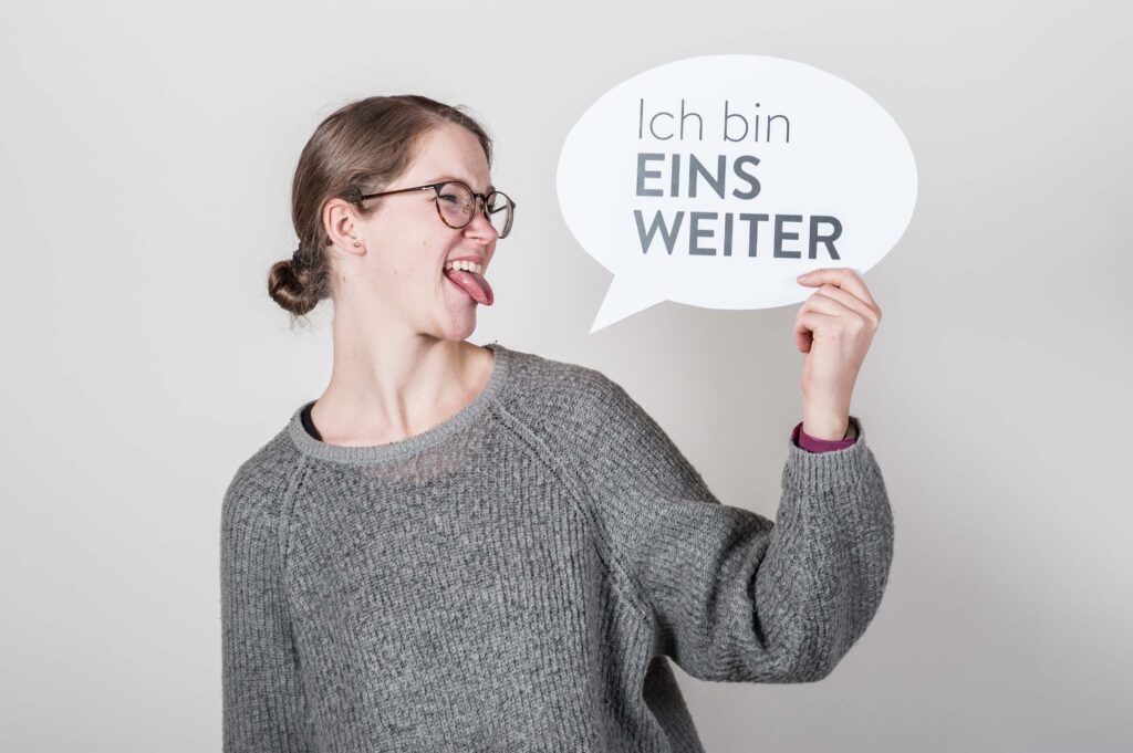 Die Galerie zeigt Menschen verschiedenen Alters, Herkunft und Geschlechts einzeln und auch gemeinsam mit Sprechblasen auf denen "Ich bin EinsWeiter" steht. 